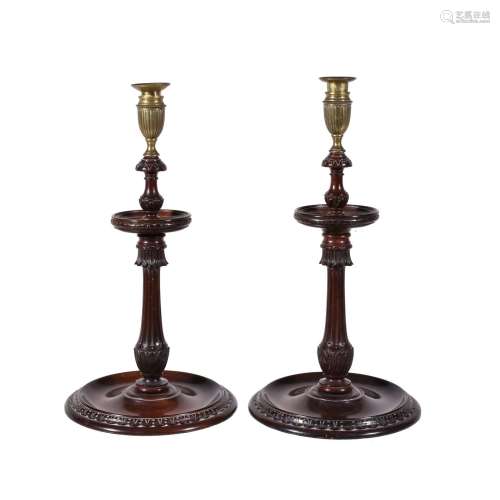 A large pair of carved and stained mahogany and brass mounted candlesticks in George III style