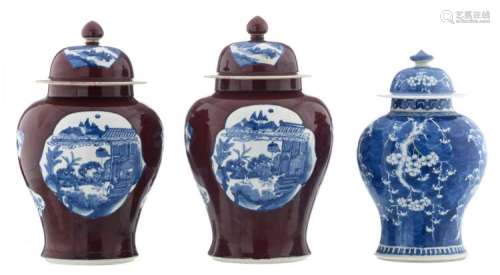Two Chinese copper red ground blue and white vases and covers, the roundels with various animated scenes, with a Kangxi mark; added a Chinese blue and white vase and cover, decorated with prunus blossoms, H 38,5 - 45 cm
