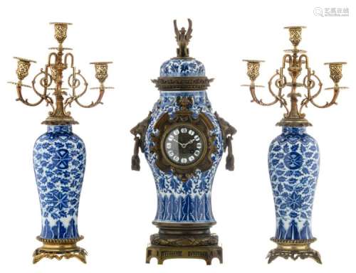 A Chinese blue and white floral and dragon relief decorated Kangxi vase and cover, mounted as clock, with bronze mounts; added two Chinese blue and white floral decorated baluster shaped Kangxi vases, mounted as chandelier, with gilt brass mounts, H 54 - 56 cm