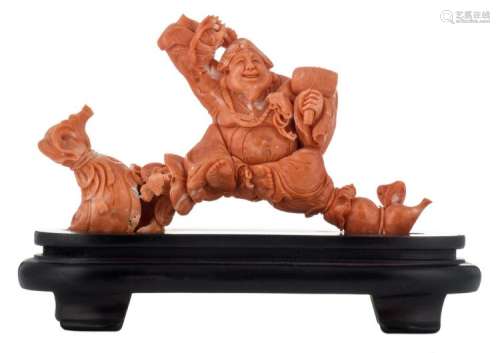 A Chinese red coral sculpture depicting a laughing Buddha with sack and hammer, signed, on a matching wooden base, H 8,5 (without base) - 12,5 cm (with base) - Weight: 196g