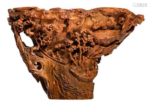 A Qing period finely carved rhinoceros horn libation cup, the sides decorated with figures in a rocky landscape and a fishing boat by the shore, H 14,7 - W 20,3 - D 12,2 cm - Weight: 653g - Provenance: Belgian private collection - Literature: e.g. T. Fok, Connoisseurship in Rhinoceros Horn Carving in China, Hong Kong, 1999