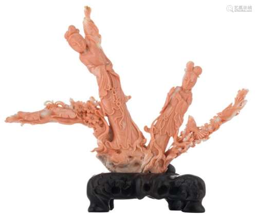 A Chinese red coral sculpture, depicting two figures, hares and birds on a flower branch, on a matching carved wooden base, H 22 (without base) - 27 cm (with base) - Weight: 794g