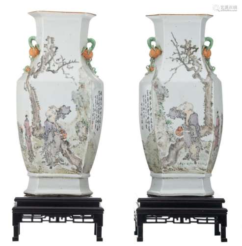 A pair of Chinese famille rose hexagonal vases, decorated with a savant and his servant, birds and flower branches, with a calligraphic text, the handles pomegranate shaped, on a matching wooden stand, H 46,5 - 47 (without stand) - 57,5 cm (with stand)