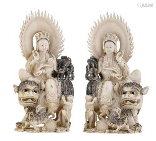 A pair of Chinese engraved and coloured ivory Bodhisattvas seated on a kylin and accompanied by children, with a Ming reign mark, first half of the 20thC, H 30 cm