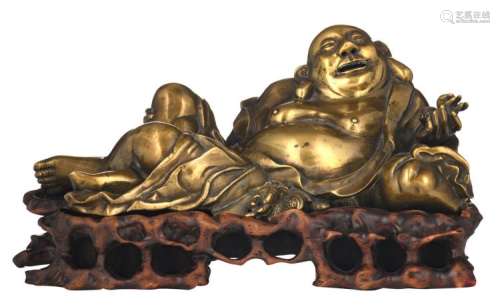 A Chinese bronze laying Buddha on a matching carved wood base, H 14 cm (with base) - W 26,5 cm