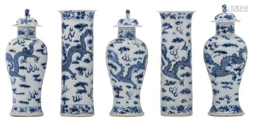 A five piece Chinese blue and white decorated garniture with dragons and a flaming pearl amid clouds, Kangxi marked, H 31 - 32,5 cm