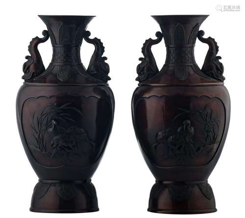 A pair of Japanese bronze patinated and relief decorated baluster shaped vases, the roundels with pheasants and cranes, the handles sea dragon shaped, H 49,5 cm