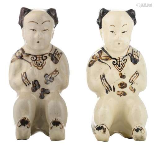 Two Chinese copper red underglaze Cizhou stoneware Song type figures, depicting seated boys, H 19 cm