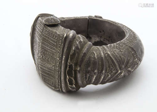 A large 19th or early 20th Century African or Middle Eastern white metal slave style bangle