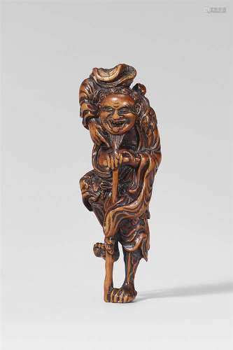 A boxwood netsuke of a laughing Tekkai Sennin with a crutch. First half 19th century