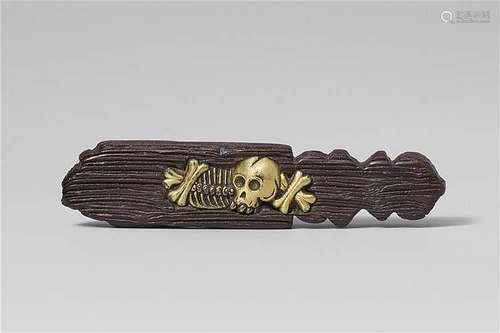 A black wood and brass netsuke of a withered sotoba with bones and a skull. Late 19th century