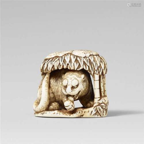 An ivory netsuke of a tiger underneath bamboo. Late 18th/early 19th century