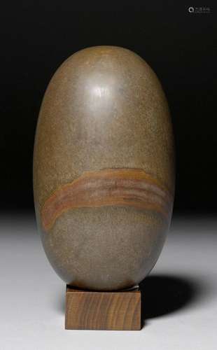 A NARMADA RIVER PEBBLE MOUNTED AS A SHIVA LINGAM.