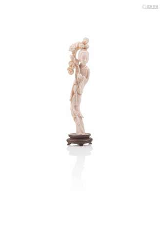 Statuette de jeune femme en corail blanc debout portant une branche de pivoines.