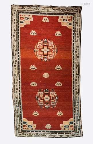 Himalayan Art A Tibetan carpet decorated with geometrical motifs over red ground