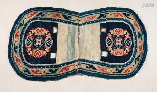 Himalayan Art An oval shaped Tibetan saddle carpet decorated with flowers over blu ground