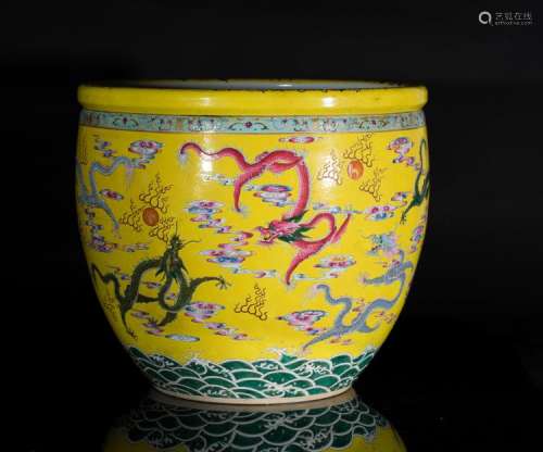 Chinese Art A porcelain fish bowl decorated with dragons chasing the flaming pearl over yellow ground and bearing a six character Qianlong seal mark within a cartouche on the upper edge China, early 20th century