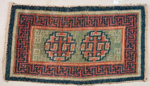 Himalayan Art A wangdeng Tibetan carpet decorated with geometric motifs over green ground