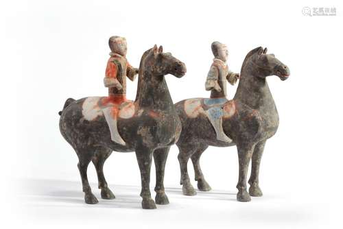 A pair of Chinese painted grey pottery figures of equestrians