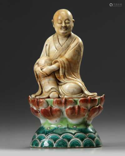 A Chinese soapstone figure of a Luohan and a famille verte stand