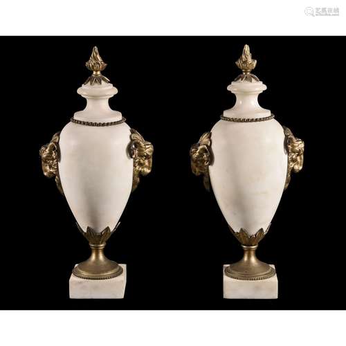 A pair of French white marble and gilt bronze mounted urns in Neoclassical style