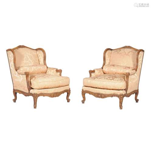 A pair of carved beech and damask upholstered wing armchairs