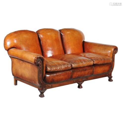 A carved mahogany and leather upholstered sofa