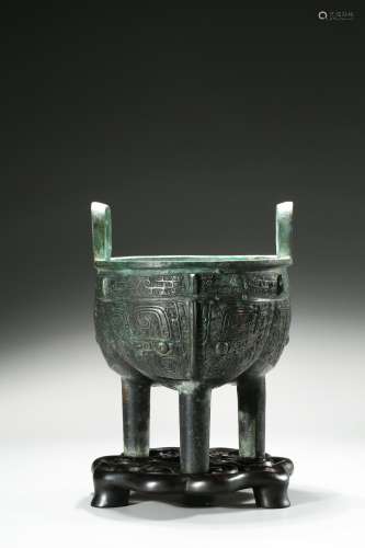 A bronze 'taotie' tripod ding vessel and stand