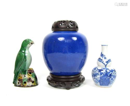 18th and 19th century A powder blue ginger jar with wooden cover and stand, a blue and white double gourd vase and a sancai parrot