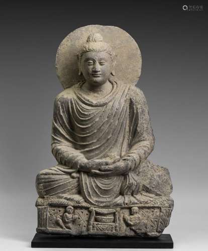 Bouddha auréolé assis en méditation, les mains en ...