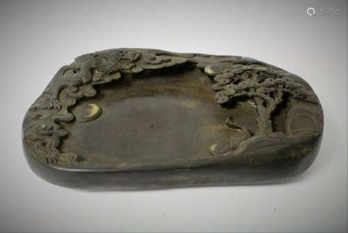 A Chinese archaic stone inkwell carved with dragon and pine tree