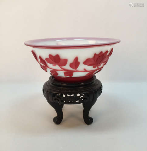 A chinese glass bowl with wood holder