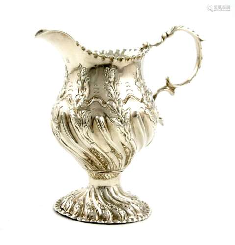 A George III silver cream jug, by Emick Romer, London 1768, fluted baluster form, with foliate