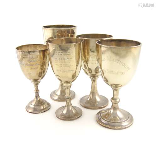A collection of five silver trophy goblets, various dates and makers, urn form, on knopped stems