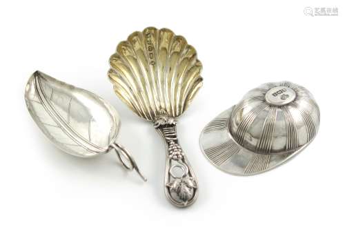 A small collection of three silver caddy spoons, comprising: one modelled as a jockey's cap, by