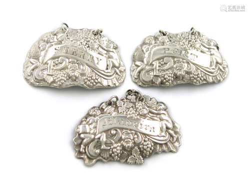 Three similar early 19th century Sheffield made silver wine labels, various dates and makers, with