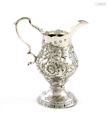 A George III silver cream jug, maker's mark worn, London 1773, baluster form, embossed foliate