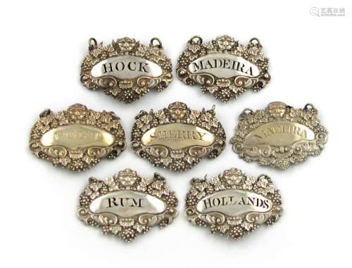 A collection of seven similar early 19th century silver wine labels, various dates and makers,