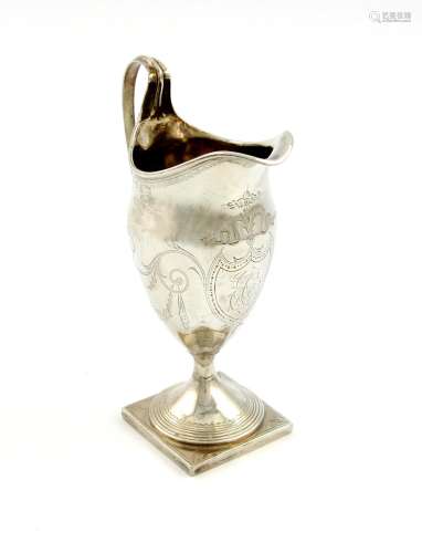 A George III silver cream jug, maker's mark worn, London 1789, helmet form, scroll handle,