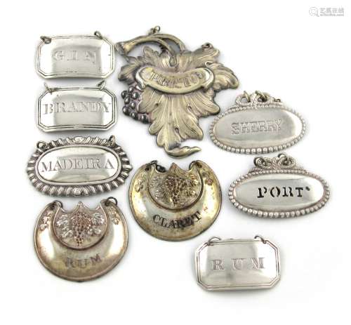 A mixed lot of wine labels, comprising silver examples: a set of three by Joseph Willmore,