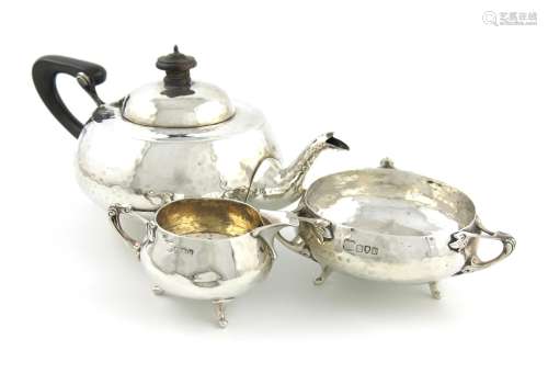 A three-piece silver tea set, by Pearce & Sons, London 1914 and 1915, circular form, spot-hammered