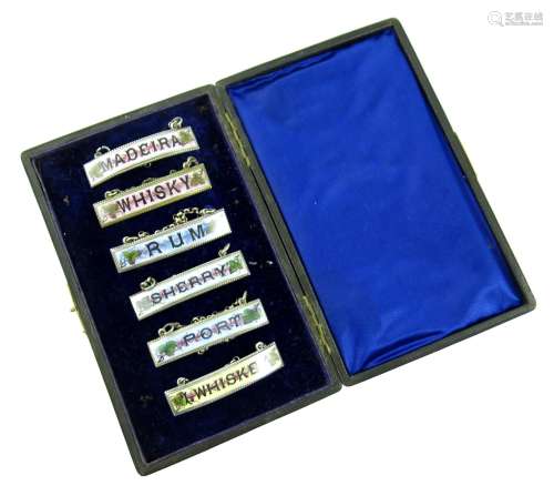 A set of six electroplated-mounted enamel wine labels, narrow rectangular form, beaded borders,