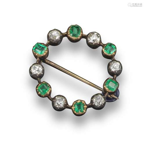 An early 20th century emerald and diamond circle brooch, alternately set with cushion-shaped