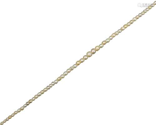 A single-row graduated natural pearl necklace, the gold clasp set with an emerald (damaged) and