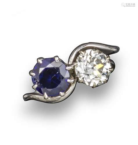 A sapphire and diamond-set crossover ring, the old brilliant cut diamond weighs approximately 1.