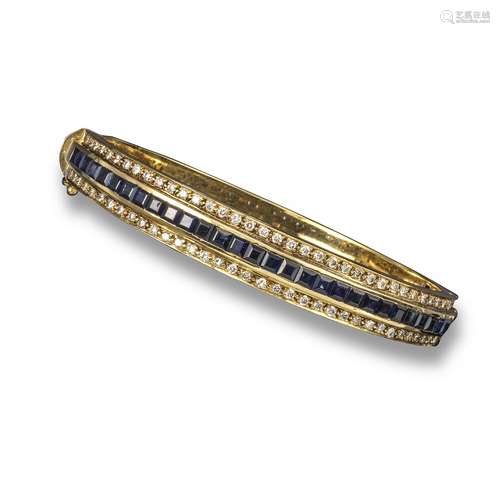 A sapphire and diamond bangle, channel-set with a line of calibré-cut sapphires within diamond