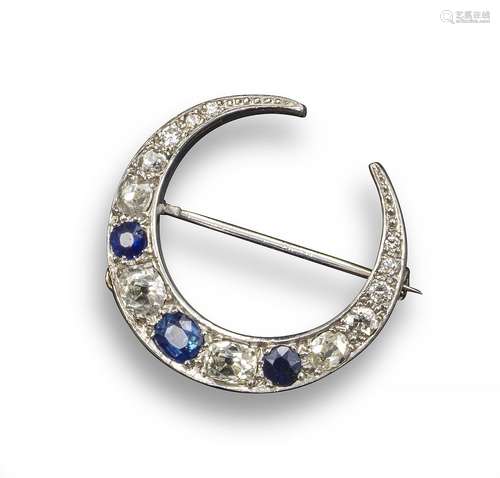 An early 20th century sapphire and diamond-set closed crescent brooch, alternately-set with