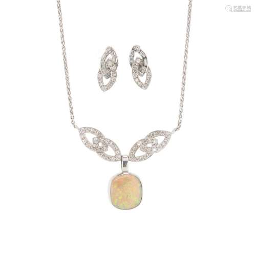 An opal and diamond pendant, the solid white opal is set on a white gold chain with interlocking