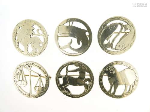 Six silver animal and zodiac brooches by Jessie Murphy, the circular silver brooches depicting Leo