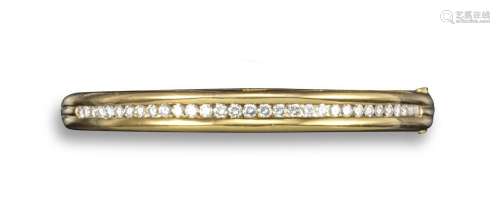 A diamond-set gold bangle, the plain polished yellow gold bangle is set with a line of graduated